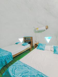 a room with two beds with blue and white sheets at Barracuda Glamping in Paso Nuevo +17 photos