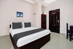a bedroom with a large bed in a room at Hotel O GRAND RESIDENCY in Ambalapulai