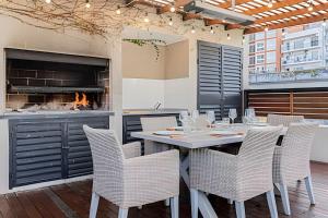 a dining room with a table and chairs and a fireplace at Oasis en Palermo c/ Terraza, Jacuzzi y Playroom in Buenos Aires