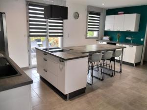 a kitchen with a counter and a island with stools at L'Orée des Vignes in Chinon
