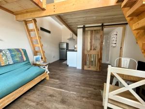 a living room with a bed and a kitchen at Glacier Alpine Lodges in East Glacier Park