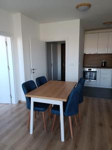 a dining room with a wooden table and blue chairs at 2 Zimmerwohnung in Shkorpilovtsi +9 photos