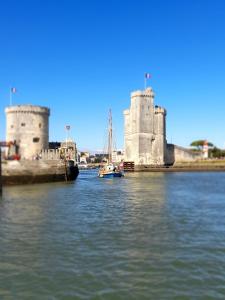 un barco en el agua frente a un castillo en La rochelle PORT DES MINIMES, en La Rochelle