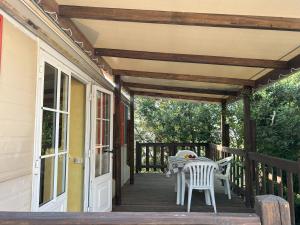 a patio with a table and chairs on a porch at AdriaCamp Mobile Homes Rosapineta in Rosapineta +51 photos