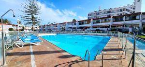 a swimming pool with lounge chairs and a building at HDFM Collection - Royal Marine Villa in Playa del Ingles