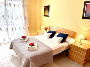 a bedroom with a large bed with two plates on it at APARTBEACH NARGAM Vista Playa in La Pineda