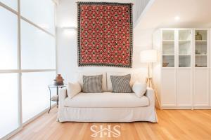 a living room with a white couch and a red rug at Domu Maria in Cagliari