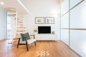 a living room with a tv and a chair at Domu Maria in Cagliari