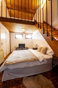 a bedroom with a large bed in a loft at Планинска вила АЛТЕА in Mostowo