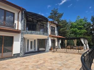 a house with a balcony and a patio at Планинска вила АЛТЕА in Mostowo