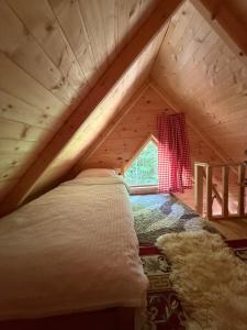 a bed in the attic of a wooden house at WildBeauty Grebaje in Vusanje