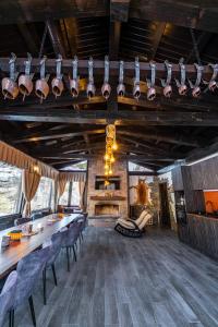 a dining room with a table and chairs and a fireplace at Планинска вила АЛТЕА in Mostowo