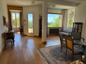 a living room with chairs and a table and windows at Magnifique villa pieds dans l eau Saint Jean Cap Ferrat in Saint-Jean-Cap-Ferrat