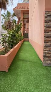 un couloir d'une maison avec de l'herbe verte dans l'établissement Appartement avec terrasse - séjour détente à quelques pas de la plage, à Agadir nʼ Aït Sa