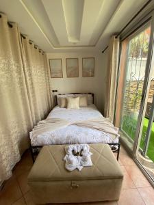 une chambre avec deux lits et une grande fenêtre dans l'établissement Appartement avec terrasse - séjour détente à quelques pas de la plage, à Agadir nʼ Aït Sa 24 autres photos