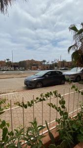 une voiture noire garée sur un parking dans l'établissement Appartement avec terrasse - séjour détente à quelques pas de la plage, à Agadir nʼ Aït Sa