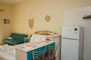a kitchen with a refrigerator and a table with chairs at Mojo studios Parga in Parga +17 photos