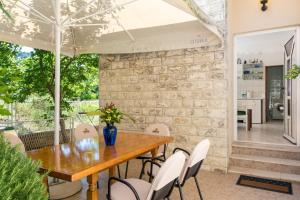a dining room with a wooden table and white chairs at Apartments Coce in Trogir