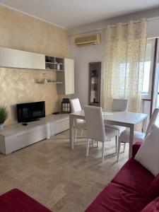 a living room with a white table and chairs at Aria di mare in Rimini