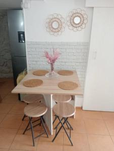 a table with four chairs and a vase with flowers at La Casita in Cangas de Morrazo