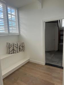 a white room with a bench and a window at African Cosy suite in The Hague +2 photos