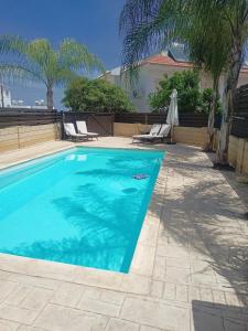 a swimming pool with two lounge chairs next to a house at Felicity - Geography of Sea - Villa with Private Pool near Kapparis Beach, Protaras in Paralimni