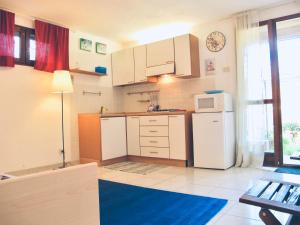 a kitchen with white cabinets and a white refrigerator at Casa ARLECCHINA in Rio Marina