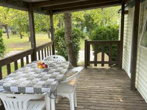 a table on a porch with a bowl of fruit on it at AdriaCamp Mobile Homes Rosapineta in Rosapineta