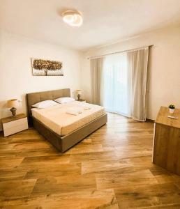 カステルサルドにあるVilla Priscila - Dimora Giovannaのベッドと木の床のある寝室