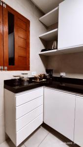 a kitchen with white cabinets and black counter tops at Casa Luz Caruaru - próx feira da sulanca in Caruaru +42 photos