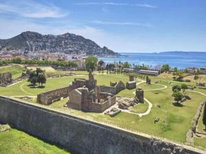 an image of the ruins of a castle with the ocean in the background at Beachfront Apartment in Platja Almadrava in Montjoys