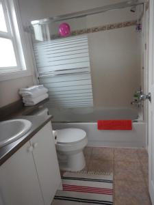 een badkamer met een wit toilet en een wastafel bij Clean and Quiet Comfortable place near Coquitlam Center mall and skytrain in Coquitlam