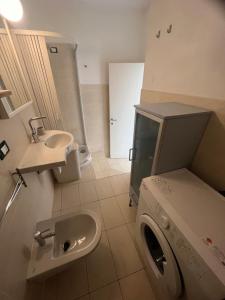 a bathroom with a washing machine and a sink at Casa Stella Residence Ea Bianca Baja Sardinia in Baja Sardinia