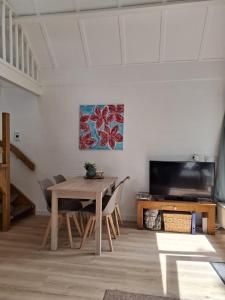 a dining room with a table and a tv at Heerlijk ! in Simpelveld
