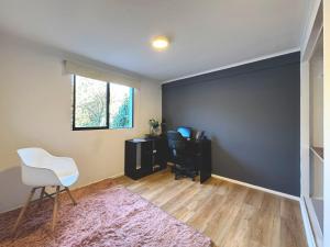 a room with a black wall and a chair and a desk at Garden House Las Condes in Santiago
