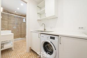una lavatrice in bagno con lavandino di Domu Chiara a Cagliari