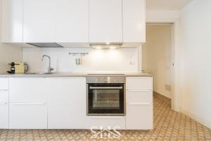 una cucina con mobili bianchi e un forno di Domu Chiara a Cagliari Altre 16 foto
