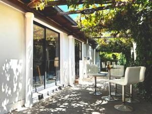a patio with two chairs and a table and windows at Garden House Las Condes in Santiago