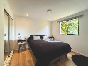 a bedroom with a black bed and a window at Garden House Las Condes in Santiago