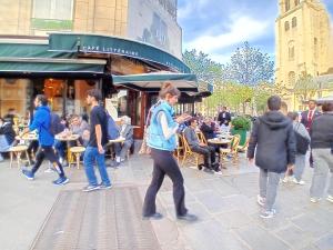 eine Gruppe von Menschen, die auf einem Bürgersteig spazieren in der Unterkunft Le Marais,center ,5 minute Eiffel tour and Louvre meusm ,1 mins metro in Paris