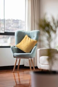 a blue chair with a yellow pillow in a living room at Modern apartment - 10 Min to City Center in Cusco