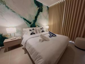 une chambre avec un lit avec des serviettes dessus dans l'établissement Baia Kristal - Vacaciones Cartagena Colombia, à Carthagène des Indes