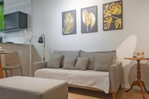 a living room with a couch and some pictures on the wall at Flórida vivo bem! in São Roque