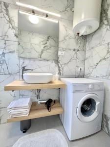 a bathroom with a washing machine and a sink at Nada in Krk
