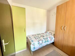 a small bedroom with a bed and a closet at Nada in Krk