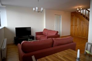 a living room with a couch and two chairs at 2-Story Penthouse with Private Sauna, Seaview Terrace & Two Bathrooms in Tallinn