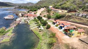 an aerial view of a river with houses and a boat at Chalés Lampião in Piranhas