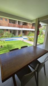 una mesa de madera y sillas frente a un edificio en Mirante da Lagoa 08, en Camassari