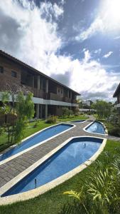 dos piscinas frente a un edificio en Mirante da Lagoa 08, en Camassari