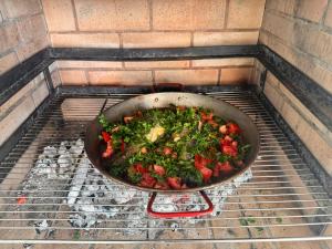 una padella di cibo sta cuocendo su una griglia di Casa La Poza a Moratalla